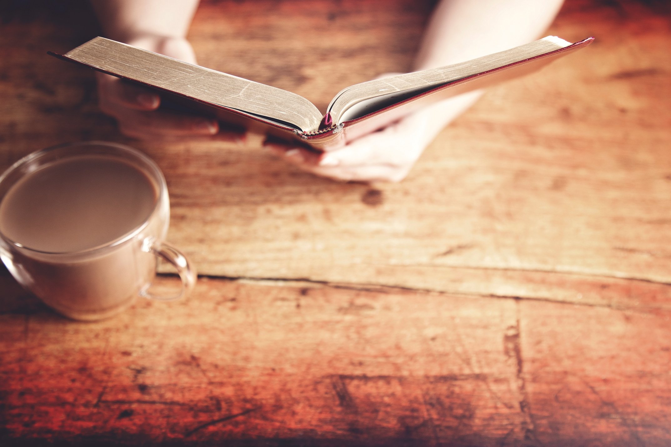 A Woman Studying Her Bible at a Rustic Wood Table